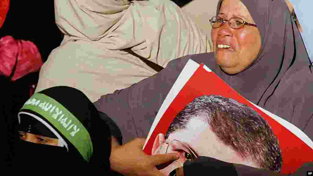 A supporter of Egypt's ousted president Mohamed Morsi weeps as she clutches his picture, Cairo, July 3, 2013.