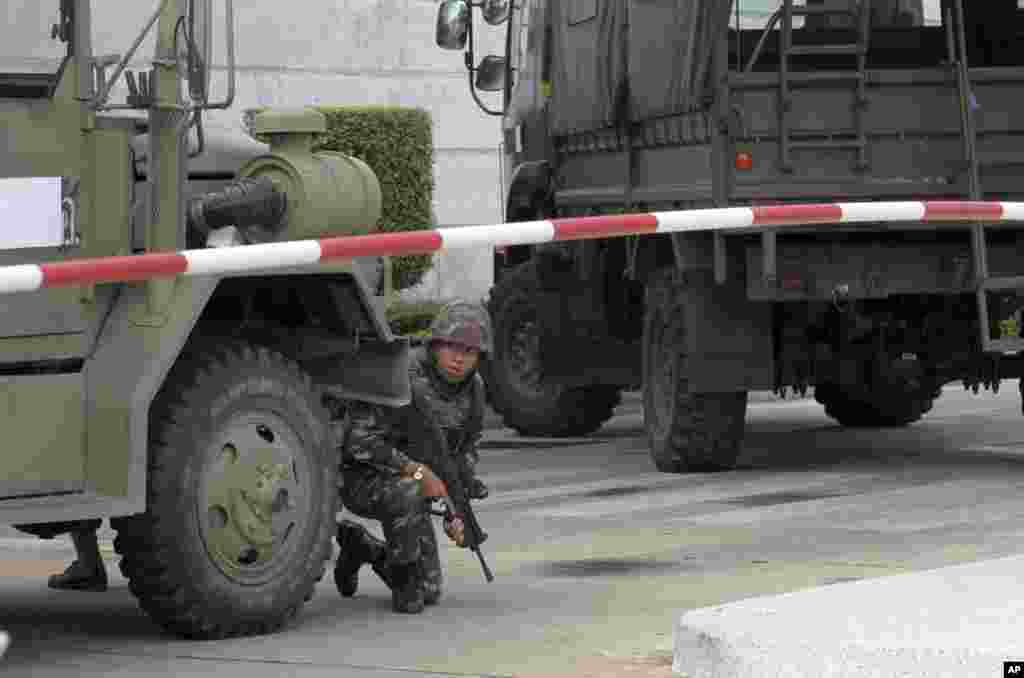An armed Thai soldier takes his position behind a military vehicle in the compound of the Army Club shortly after the military staged a coup, in Bangkok, May 22, 2014.