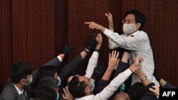 在這幅2020年5月8日拍攝的照片中，泛民主派議員朱凱迪在保安試圖制服他時呼喊。