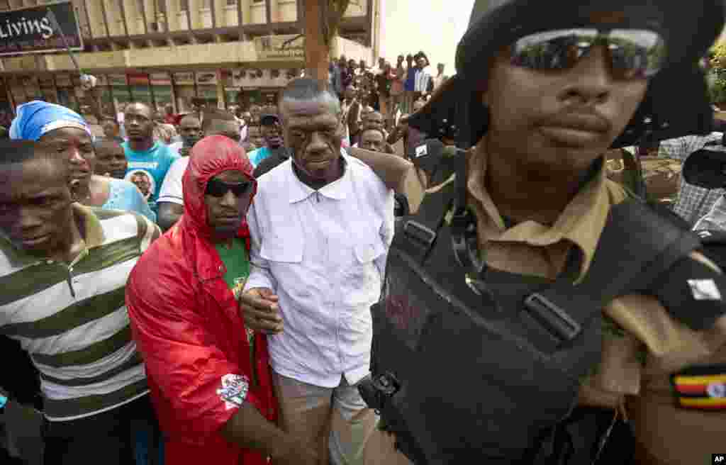 Kizza Besigye , au centre, est arrêté par la police après avoir tenté de protester avec ses partisans le long d'une rue dans le centre de Kampala, Ouganda, 15 février 2016.
