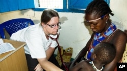 An MSF doctor examines a baby in Pibor, in Jonglei State in South Sudan. People who went into hiding following recent attacks continue to come in for urgently needed medical care at MSF's re-opened facilities.