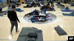 ARCHIVO - Migrantes descansan en un refugio improvisado, el 6 de enero de 2023, en Denver. 