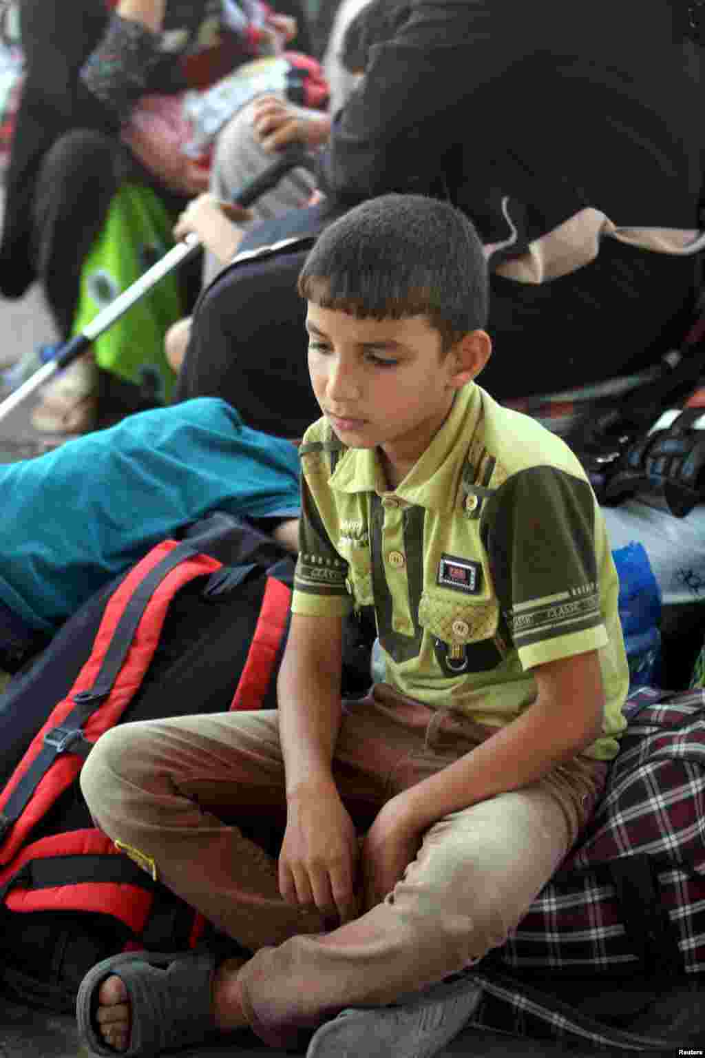 An internally displaced Iraqi Sunni boy sits with his family, who fled the violence in the city of Ramadi, on the outskirts of Baghdad, May 19, 2015. 