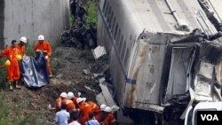 Regu penyelamat menggotong tubuh korban tewas yang ditemukan di antara rongsokan kereta api yang bertabrakan di Propinsi Zhejiang (24/7).
