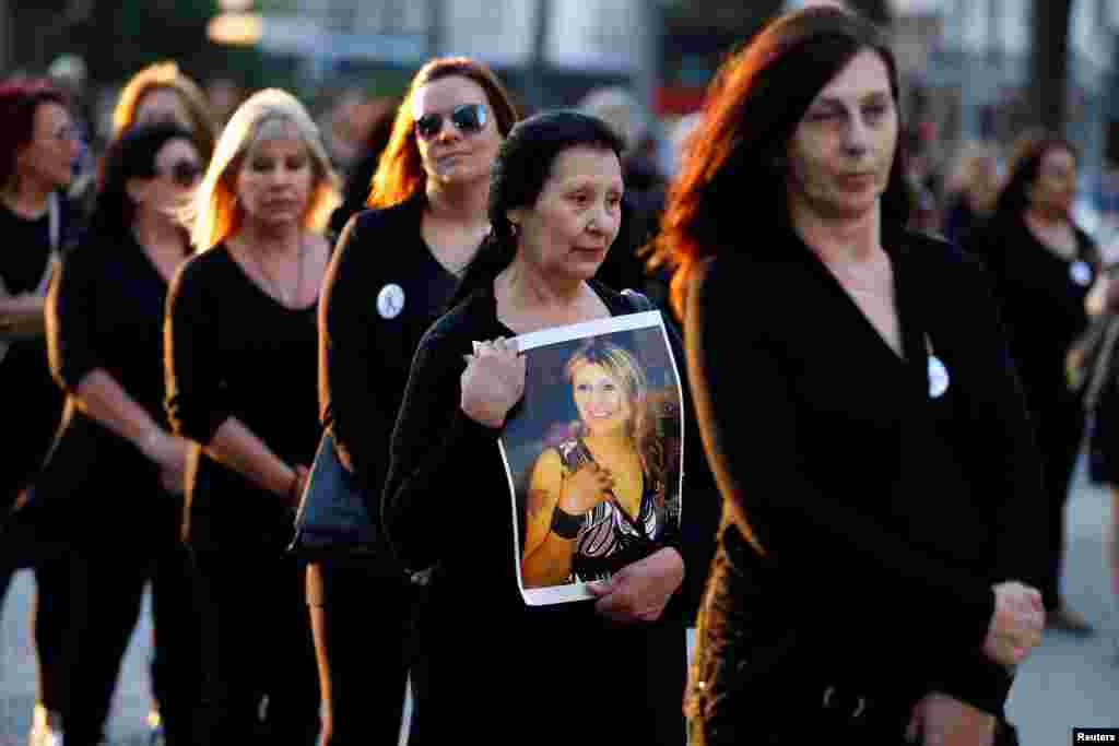 Seorang perempuan membawa foto putrinya, yang merupakan korban kekerasan dalam rumah tangga, dalam demonstrasi yang diorganisir oleh "Mujeres de Negro" (Perempuan Berbaju Hitam) untuk melawan kekerasan berbasis gender di Montevideo, Uruguay (25/11). (Reuters/Andres Stapff)