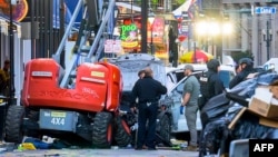 EDITORS NOTE: Graphic content / Police investigators surround the white Ford F-150 pickup truck that crashed into a work lift after allegedly driving into a crowd of New Year's revelers in the French Quarter of New Orleans, Louisiana, on January 1, 2025.
