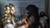 FILE -An Afghan woman, right, is checked by a nutritionist at a clinic run by the World Food Program in Kabul, Afghanistan, Jan. 26, 2023. Many female doctors have left Afghanistan since the Taliban returned to power in August 2021.