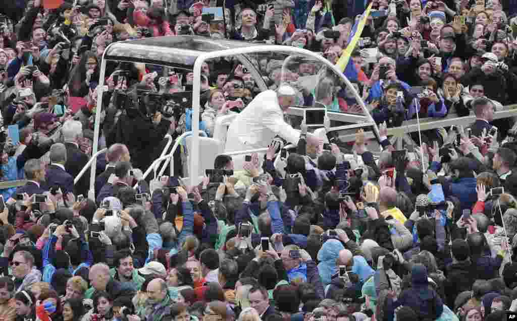 Pope Francis salutes faithful in St. Peter's square at the Vatican, April 5, 2015.