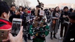 FILE - A journalist operate a harness with multiple recording devices capable of recording and live streaming outside the Great Hall of the People in Beijing, China. 