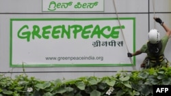 Des militants de Greenpeace devant leur immeuble avec des banderoles " démocratie " et " FreeSpeech " à Bangalore , le 15 mai 2015. 