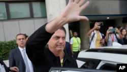 El expresidente de Brasil, Jair Bolsonaro, saluda a sus simpatizantes afuera del aeropuerto Santos Dumont a su llegada a Río de Janeiro, Brasil, el jueves 29 de junio de 2023. (Foto AP/Silvia Izquierdo)