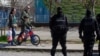 Montenegro, Podgorica, People pass behind a police checkpoint after the government tightened up measures for coronavirus 