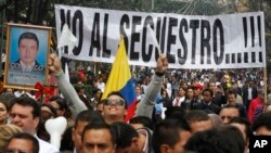 ARCHIVO - Personas marchan con un cartel que dice "No al secuestro" en protesta contra los secuestros en Bogotá, Colombia, el 6 de diciembre de 2011.