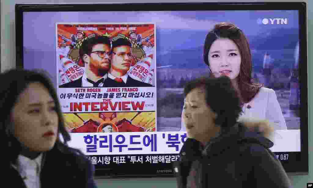 Seorang tentara Korea Selatan melewati televisi yang menayangkan berita mengenai film "The Interview" dari Sony Pictures di stasiun kereta Seoul (22/12). (AP/Ahn Young-joon)