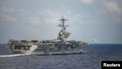 FILE - An F/A-18F Super Hornet launches from the flight deck of the U.S. Navy aircraft carrier USS Theodore Roosevelt in the Philippine Sea on March 18, 2020. The Navy announced on Sept. 12, 2024, that it was moving the aircraft carrier out of the Middle East.