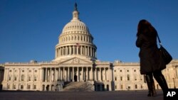 FILE - A woman walks past the U.S. Capitol in Washington.