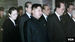 Kim Jong Un (tengah) memberikan penghormatan di depan jenazah ayahnya (26/12). Riwayat hidup Kim Jong Un yang pasti tidak banyak diketahui oleh media Barat.