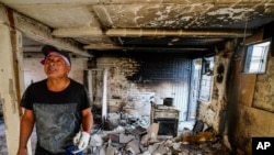 Marco Delgadillo observa los daños en su hogar tras un incendio en el barrio de El Olivar, en Viña del Mar, Chile, el lunes 5 de febrero de 2024.