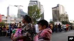 Warga berdiri di jalan-jalan setelah mendengar alarm peringatan gempa di Mexico City, Sabtu, 23 September 2017. 