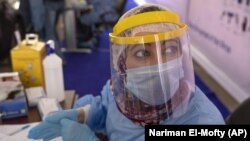 Un agent de santé portant un équipement de protection se prépare à prélever des échantillons au Caire, le 17 juin 2020.
