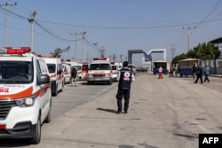 Ambulans milik Kementerian Kesehatan Palestina melintasi gerbang untuk memasuki perbatasan Rafah di Jalur Gaza selatan sebelum menyeberang ke Mesir, 1 November 2023. (MOHAMMED ABED / AFP)