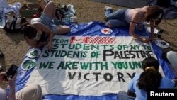 Students at Columbia University paint a response to a message written by Palestinians in Rafah thanking students for their support as they continue to maintain a protest encampment on campus, April 28, 2024.