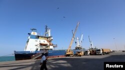 FILE - A coastguard walks past a ship docked at the Red Sea port of Hodeida, Yemen, Jan. 5, 2019. 