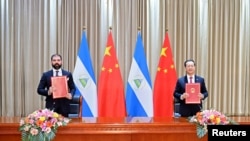 El viceministro de Relaciones Exteriores de China, Ma Zhaoxu, y el representante de Nicaragua, Laureano Ortega, asisten a la firma del comunicado conjunto sobre la reanudación de las relaciones diplomáticas entre la República Popular China y la República de Nicaragua.