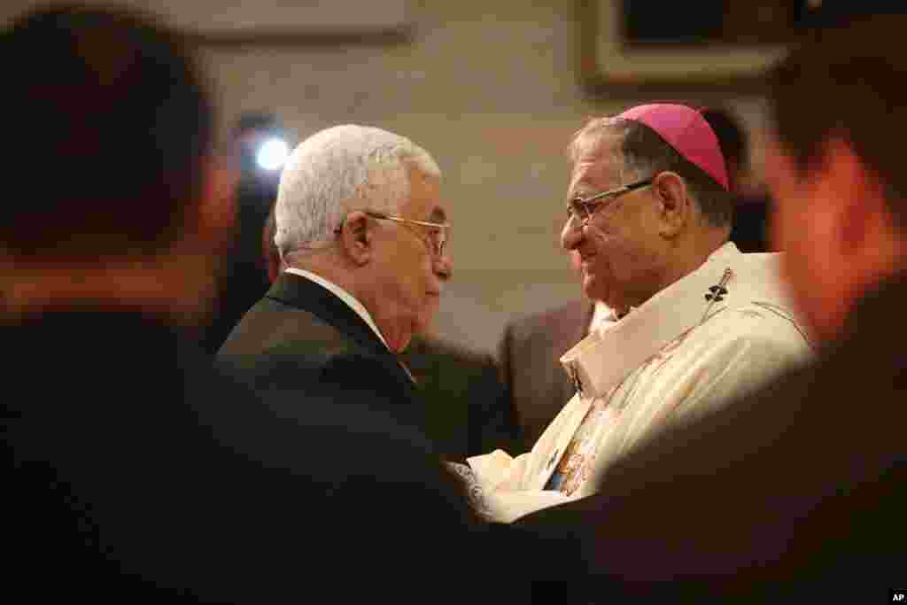 Shugaban Falasdinawa, Mahmoud Abbas, yana gaisawa da babban fada na Birnin Qudus, Fouad Twal a lokacin taron addu'ar jajiberen Kirsimeti a majami'ar Nativity ta birnin Bethlehem a yankin Yammacin kogin Jordan.