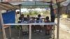 Sekelompok anak-anak pelajar sekolah dasar yang berteduh pada salah satu bangunan kayu seusai pulang sekolah di kawasan pengungsian Balaroa, Palu Barat, Sulawesi Tengah, 22 Juli 2019. (Foto: Yoanes Litha/VOA)