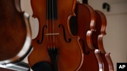 Violins hang in a workshop in Wisconsin, May 8, 2017.