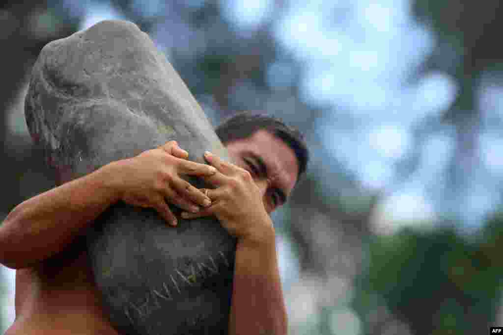 A competitor takes part in 100-kilo (200 lbs) stone-lifting event during the annual Heiva Tu’aro Ma’ohi sporting event in the capital of the French Polynesian island of Tahiti. “Heiva,” which comes from the Polynesian words meaning “to assemble” and “community places,” celebrates traditional Polynesian activities, including festivals, music, dancing, singing, and sporting events.