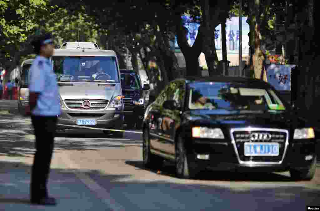 A black minivan (behind silver Mercedes minivan) believed to be carrying disgraced Chinese politician Bo Xilai arrives at the Jinan Intermediate People's Court ahead of the fifth day of Bo's trial in Jinan, Shandong province, August 26, 2013. 