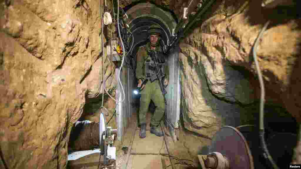 An Israeli army officer gives explanations to journalists during an army organized tour in a tunnel said to be used by Palestinian militants for cross-border attacks, July 25, 2014. 