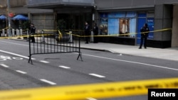 FILE - Police officers stand near the scene where UnitedHealthcare CEO Brian Thompson was gunned down in New York City, Dec. 4, 2024.