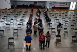 Volunteers help a group of elderly fill out forms in order to receive a second dose of the Sinovac COVID-19 vaccine at the Americas Cultural Center, in Ecatepec, Mexico, April 3, 2021.