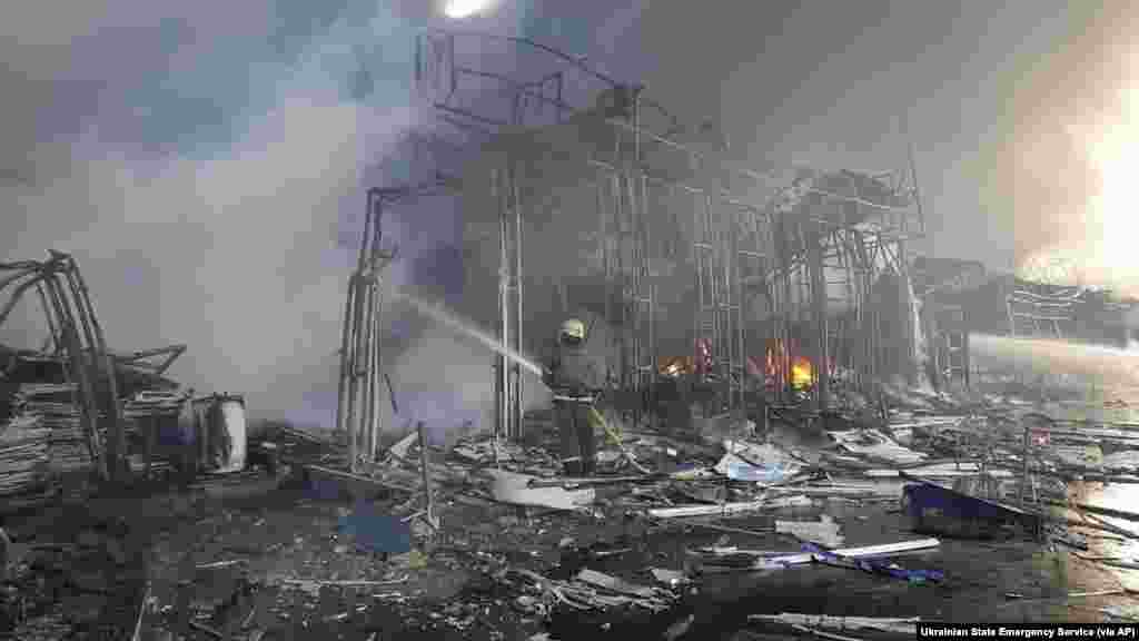 Firefighters work to extinguish a fire at a market hit by shelling in Kharkiv, Ukraine, March 16, 2022.