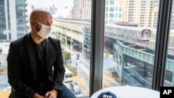 Dr. Demetre Daskalakis, New York City deputy health commissioner, speaks to a reporter on battling the coronavirus pandemic through contact tracing near the Queensboro Plaza commuter thoroughfare, Aug. 12, 2020, in New York. 