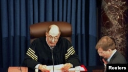 Supreme Court Chief Justice William Rehnquist reads the vote tally in the Senate's impeachment trial of President Clinton, as Clinton's attorney Charles Ruff (L) listens, February 12. The Senate rejected both counts, with neither charge receiving a…