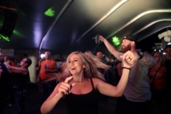 Rallygoers dance at a rock show Aug. 5, 2021, in Sturgis, SD. The Sturgis Motorcycle Rally started Friday, even as coronavirus cases are rising in South Dakota.