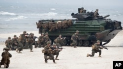 Des Marines américains avec des véhicules d'assaut amphibies prennent part à une opération de débarquement pendant l'exercice Baltops 2018 le long de la mer Baltique près du village lituanien de Nemirseta, le 4 juin 2018. 