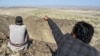 A local resident shows a mountain at the Koh-e-Sabz area of Pakistan's southwest Baluchistan province where Iran launched an airstrike, on Jan. 18, 2024.