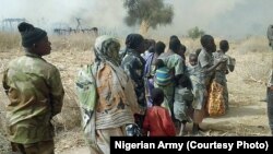 FILE - Nigerian soldiers rescue some people after chasing Boko Haram fighters out of a village in the Sambisa forest in Borno state, in 2016.