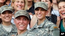 FILE - U.S. Army 1st Lt. Shaye Haver, center, and Capt. Kristen Griest, right, pose for photos with other female West Point alumni after an Army Ranger school graduation ceremony at Fort Benning, Ga., Aug. 21, 2015. 