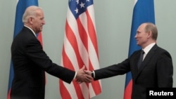 ARHIVA - Predsednik Rusije Vladimir Putin i tadašnji potpredsednik SAD Džo Bajden rukuju se u Moskvi, 10. marta 2011. (Foto: Reuters/Alexander Natruskin)