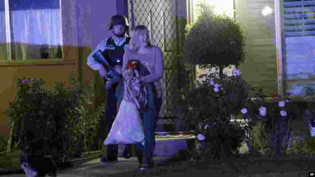 Un policier accompagne une femme chez elle après la fusillade, à Redlands, en Californie, 2 décembre 2015., 