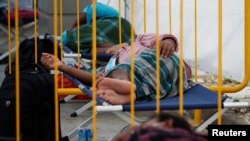 Para pekerja mingran beristirahat di fasilitas isolasi tes usap virus corona (Covid-19) sambil menunggu hasil tes di Singapura, 15 Mei 2020. (Foto: Reuters)