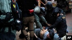 La policía de Hong Kong detiene a un manifestante durante una marcha el miércoles 25 de diciembre de 2019.