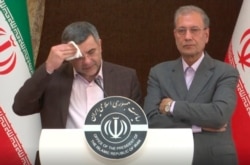 The head of Iran's counter-coronavirus task force, Iraj Harirchi, left, attends a press briefing with government spokesman Ali Rabiei, in Tehran, Iran, Feb. 24, 2020. Harirchi has tested positive for the virus.