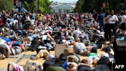 Para demonstran berbaring di jalan menghadap ke Gedung Putih dalam unjuk rasa di Lafayette Square untuk memprotes kebrutalan polisi dan rasisme, di Washington D.C., 7 Juni 2020. 